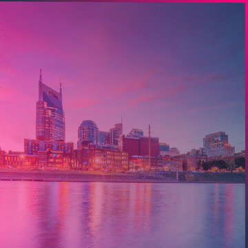 City skyline with tall buildings and waterfront, under a vibrant pink and purple sunset sky, reflected in the calm river below—capturing the energy of Nashville as Memcyco makes its mark at the IAFCI Conference.